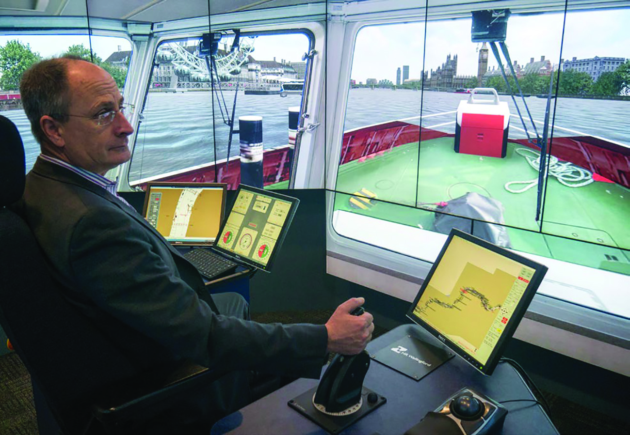 Andy Mitchell Tideway CEO at the helm of a tug in the HR Wallingford River Thames simulation